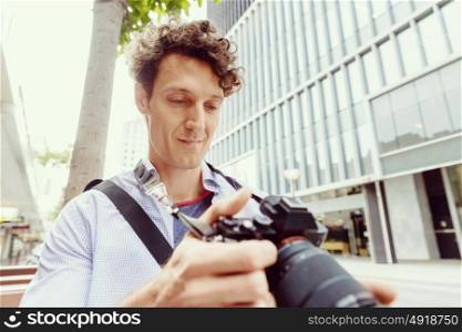 Male photographer taking picture. Professional photographer taking picture in city