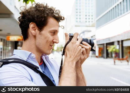 Male photographer taking picture. Professional photographer taking picture in city