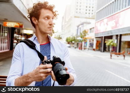 Male photographer taking picture. Professional photographer taking picture in city