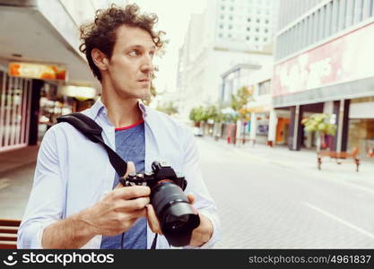 Male photographer taking picture. Professional photographer taking picture in city