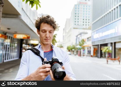 Male photographer taking picture. Professional photographer taking picture in city