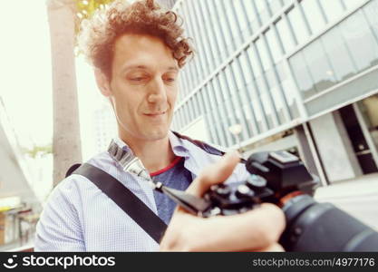 Male photographer taking picture. Professional photographer taking picture in city