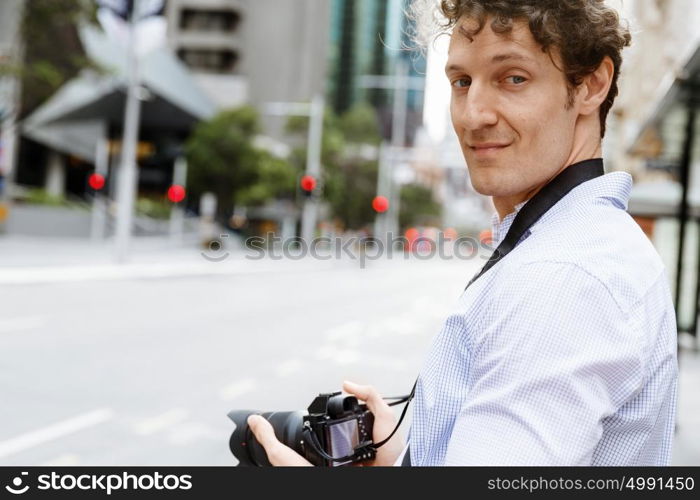 Male photographer taking picture. Professional photographer taking picture in city