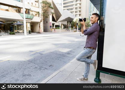 Male photographer taking picture. Professional photographer taking picture in city