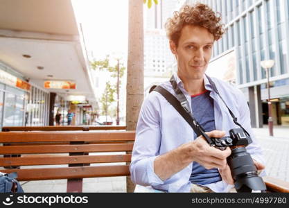 Male photographer taking picture. Professional photographer taking picture in city