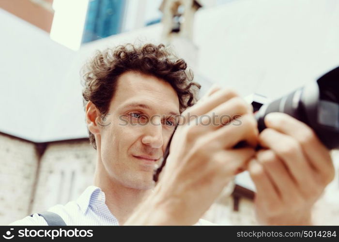 Male photographer taking picture. Professional photographer taking picture in city