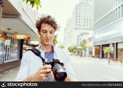 Male photographer taking picture. Professional photographer taking picture in city