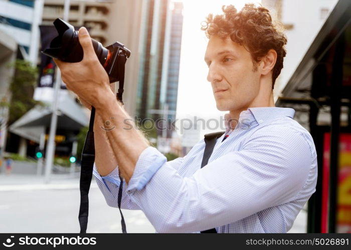 Male photographer taking picture. Professional photographer taking picture in city