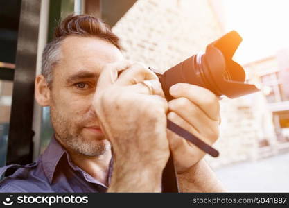 Male photographer taking picture. Professional photographer taking picture in city