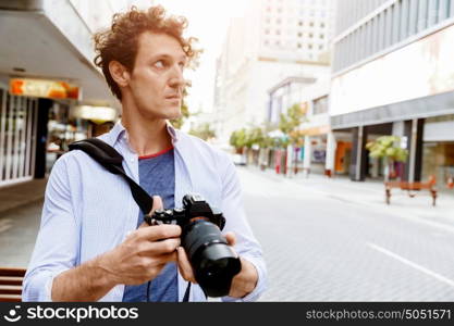 Male photographer taking picture. Professional photographer taking picture in city