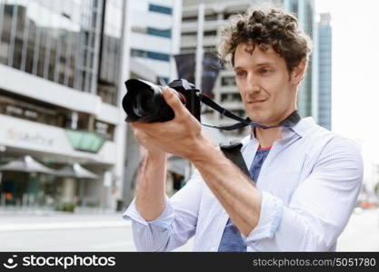 Male photographer taking picture. Professional photographer taking picture in city