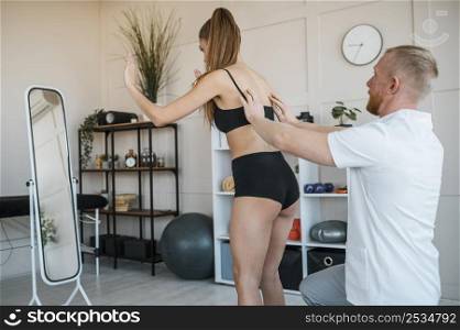male physiotherapist checking female patient s balance