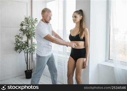 male physiotherapist checking woman s core