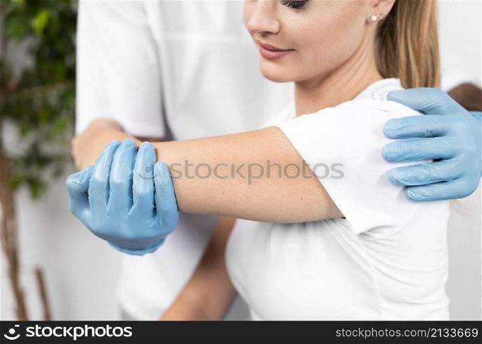 male physiotherapist checking woman s shoulder flexibility