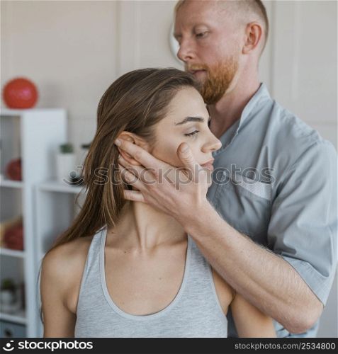 male physiotherapist doing physical exercises with female patient
