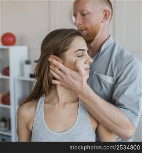 male physiotherapist doing physical exercises with female patient
