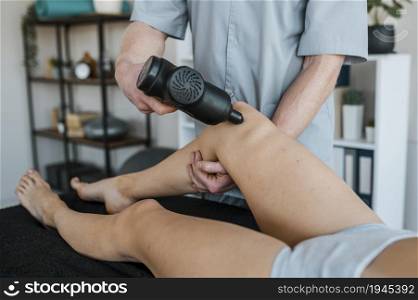 male physiotherapist using equipment female patient during physical therapy session. High resolution photo. male physiotherapist using equipment female patient during physical therapy session. High quality photo
