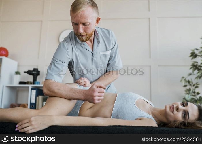 male physiotherapist with female patient during kinesiology session