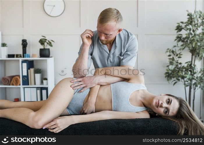 male physiotherapist with female patient during physical therapy session