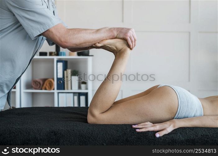 male physiotherapist with woman during physical therapy session