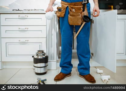 Male plumber installing water filter in the kitchen. Handywoman with toolbag repair sink, sanitary equipment service at home. Male plumber installing water filter in kitchen