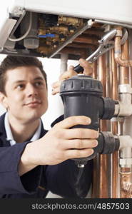 Male Plumber Working On Central Heating Boiler