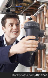 Male Plumber Working On Central Heating Boiler