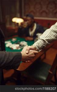 Male poker players shake hands in casino. Games of chance addiction, risk, gambling house. Men leisures with whiskey and cigars. Male poker players shake hands in casino