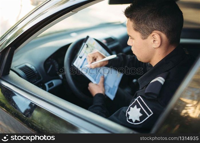 Male policeman in uniform sitting in car and writes a fine. Law protection, car traffic inspector, safety control job. Male policeman sitting in car and writes a fine