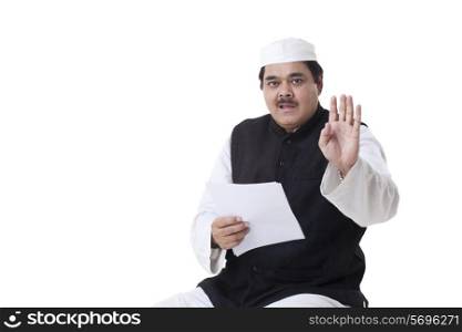 Male politician gesturing while reading document