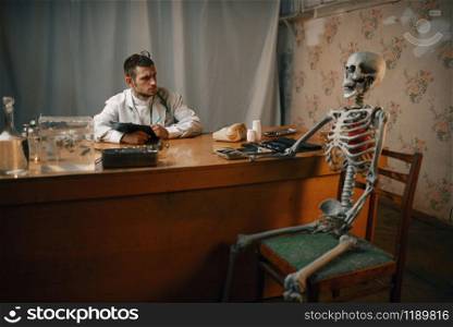 Male psychiatrist and the patient skeleton, mental hospital. Doctor in clinic for the mentally ill. Psychiatrist and patient skeleton, mental hospital