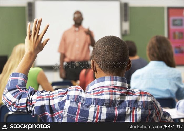 Male Pupil Raising Hand In Class