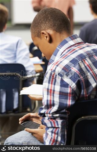 Male Pupil Sending Text Message In Classroom