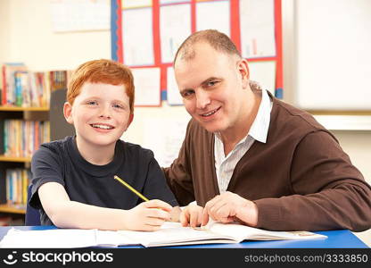 Male Pupil Studying in classroom with teacher