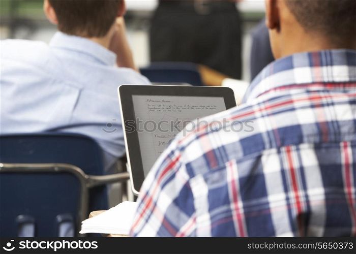 Male Pupil Using Digital Tablet In Classroom