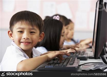 Male Pupil Using Keyboard During Computer Class In Chinese School Classroom