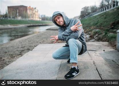 Male rapper posing on the street, urban dancing. Modern dance style. Male rapper posing on the street, urban dancing