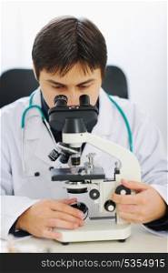 Male researcher working with microscope