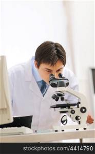 Male researcher working with microscope in laboratory