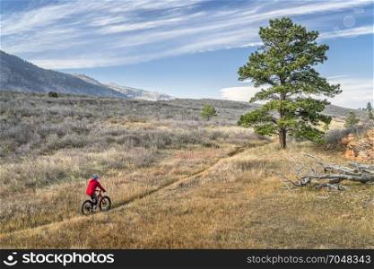 male riding a fat bike on single track trail in Colorado foothills, fall scenery