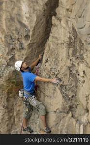 Male rock climber scaling a rock face
