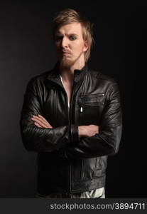 Male rocker wearing black leather jacket, dark background and studio shot