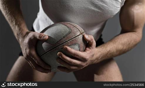 male rugby player holding ball with both hands