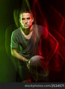 male rugby player holding ball with color effect