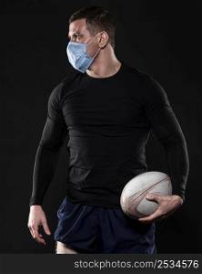 male rugby player with medical mask ball