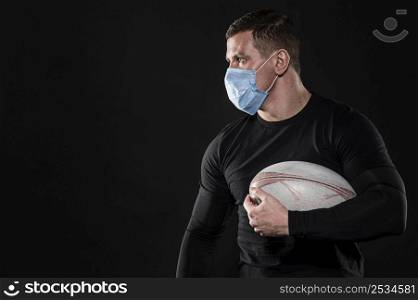 male rugby player with medical mask copy space