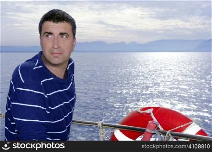 Male sailorman on blue sea boat looking ocean horizon