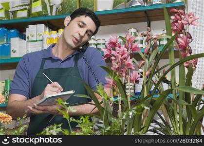 Male sales clerk taking order in a flower shop