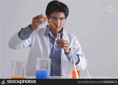 Male scientist adding liquid to the test tube