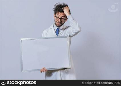 Male scientist in white coat holding and pointing at a blank whiteboard. Disheveled-haired man holding blank whiteboard, Amazed man in white coat pointing at a whiteboard